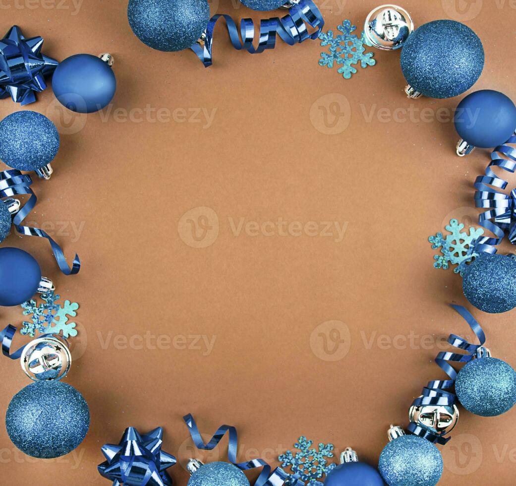 Christmas frame from Christmas blue balls, serpentine on a brown background. Christmas background. Flat lay, top view. Copy space. photo