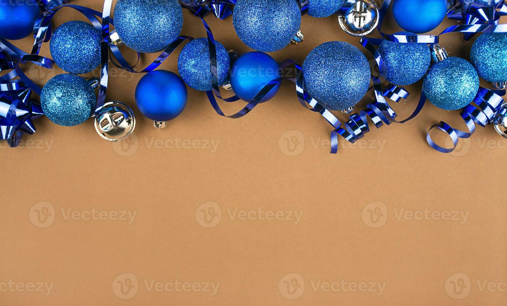 Christmas background of blue balls and streamer on a brown table. Christmas background. Flat lay, top view. Copy space. photo