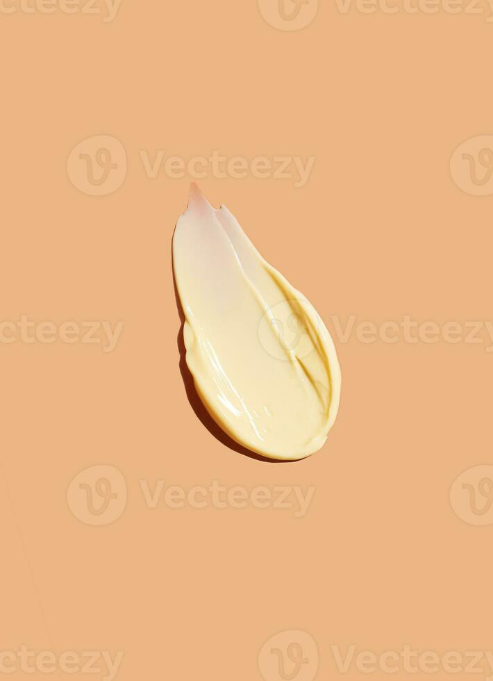 Yellow cosmetic smear of cream texture on a beige background. Skin care. Copy space. photo