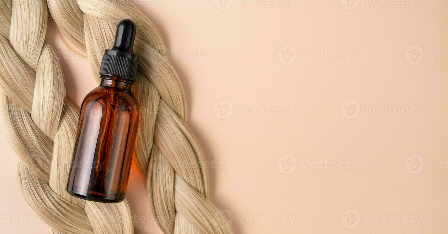 Hair serum. A vial with serum lies on blond hair. Hair treatment. photo