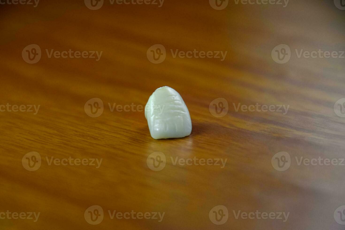 Tooth, metal ceramic crown on the table. Denture made of metal ceramics photo