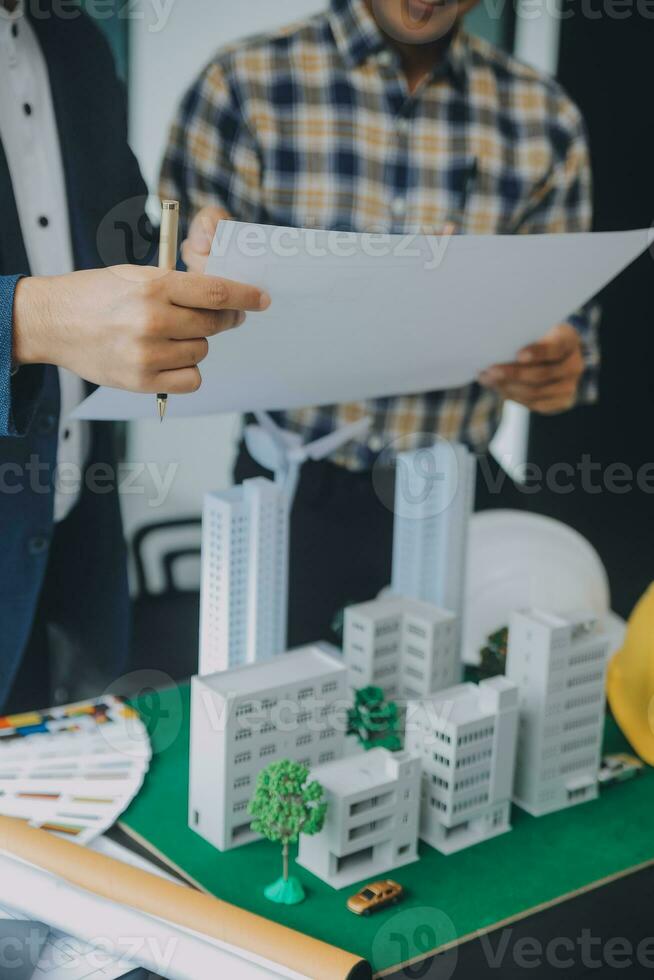 Construction and structure concept of Engineer or architect meeting for project working with partner and engineering tools on model building and blueprint in working site, contract for both companies. photo