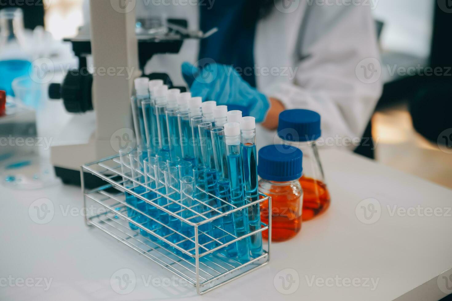 biochemical research scientist team working with microscope for coronavirus vaccine development in pharmaceutical research labolatory, selective focus photo