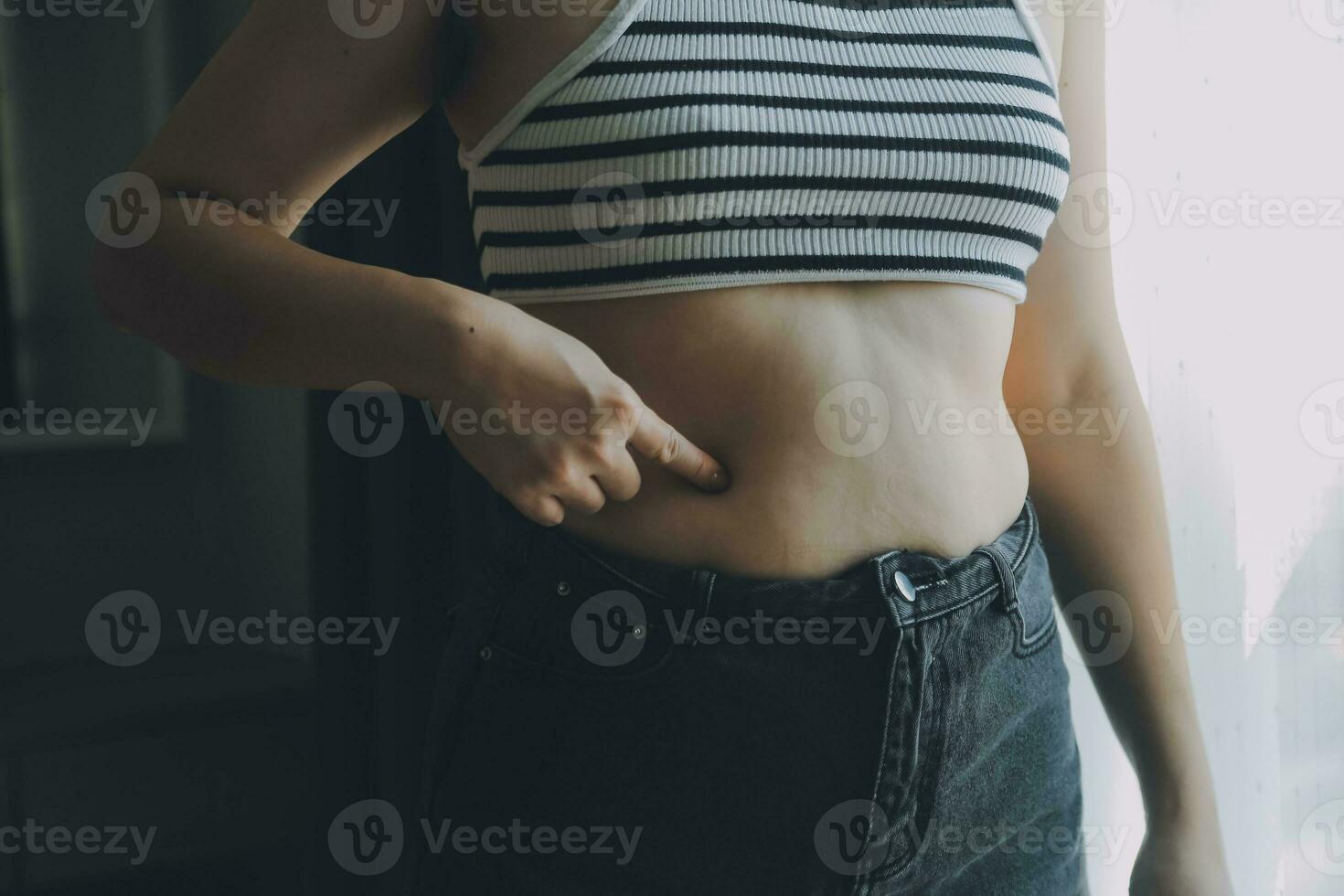 Women body fat belly. Obese woman hand holding excessive belly fat. diet lifestyle concept to reduce belly and shape up healthy stomach muscle. photo