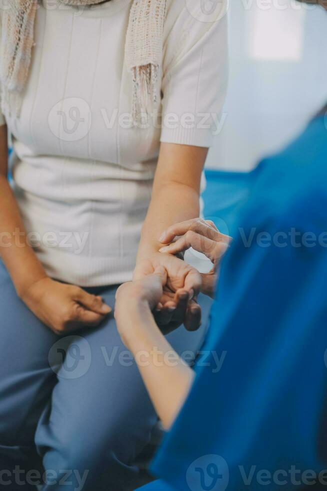 Young asian caretaker with 60s asia elderly woman consulting and encourage, take a history and recommend the right treatment, holding hands and encouraging photo