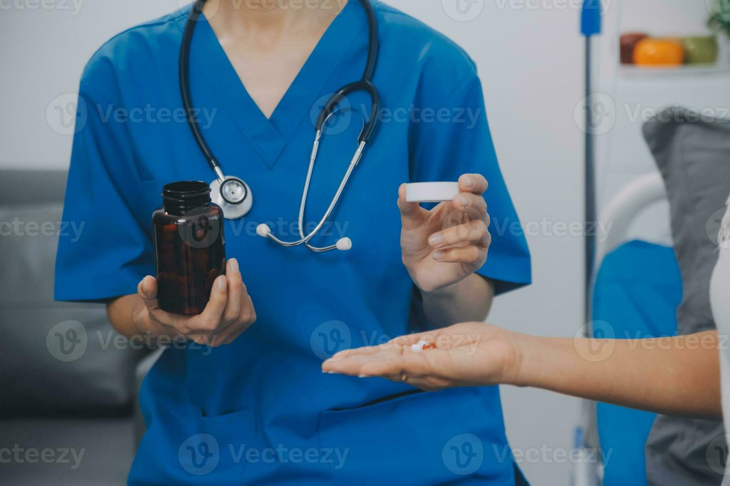 Asian woman nurse holding a medicine bottle and telling information to Asian senior woman before administering medication. Caregiver visit at home. Home health care and nursing home concept. photo