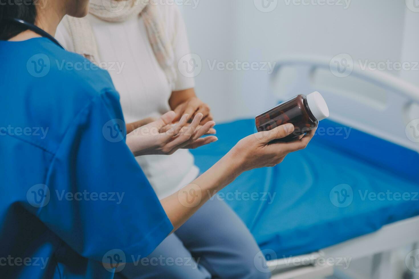 Asian woman nurse holding a medicine bottle and telling information to Asian senior woman before administering medication. Caregiver visit at home. Home health care and nursing home concept. photo