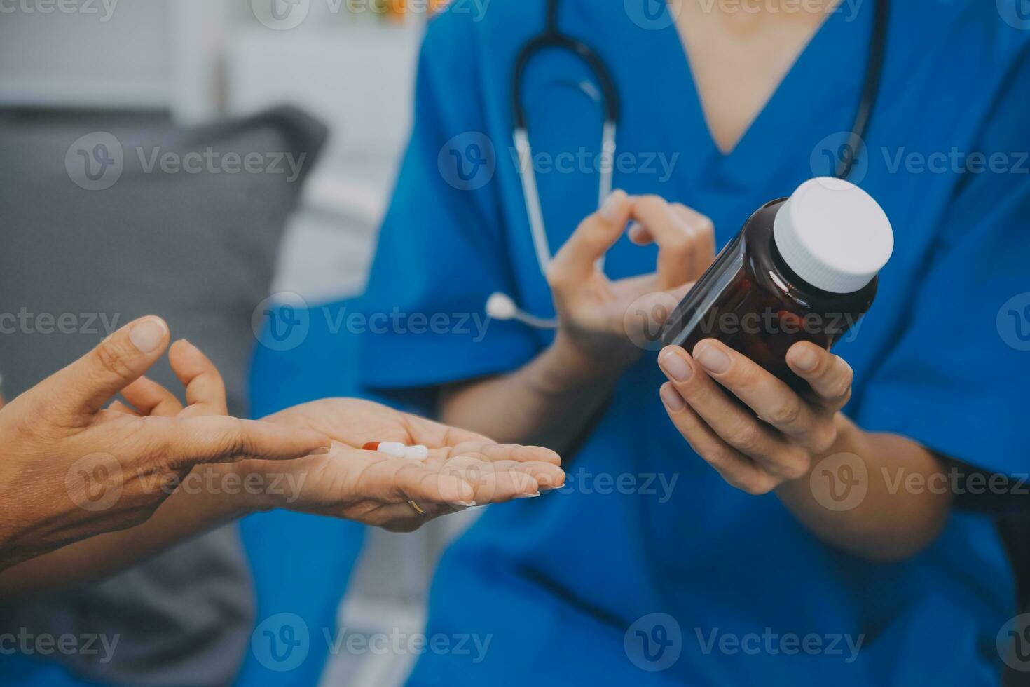 Asian woman nurse holding a medicine bottle and telling information to Asian senior woman before administering medication. Caregiver visit at home. Home health care and nursing home concept. photo