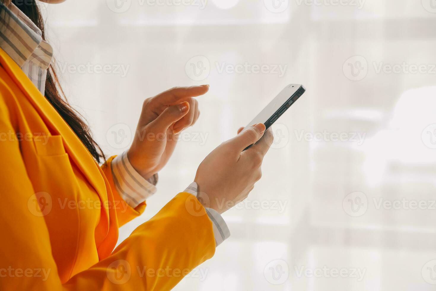 Young smiling business woman using smartphone near computer in office, copy space photo