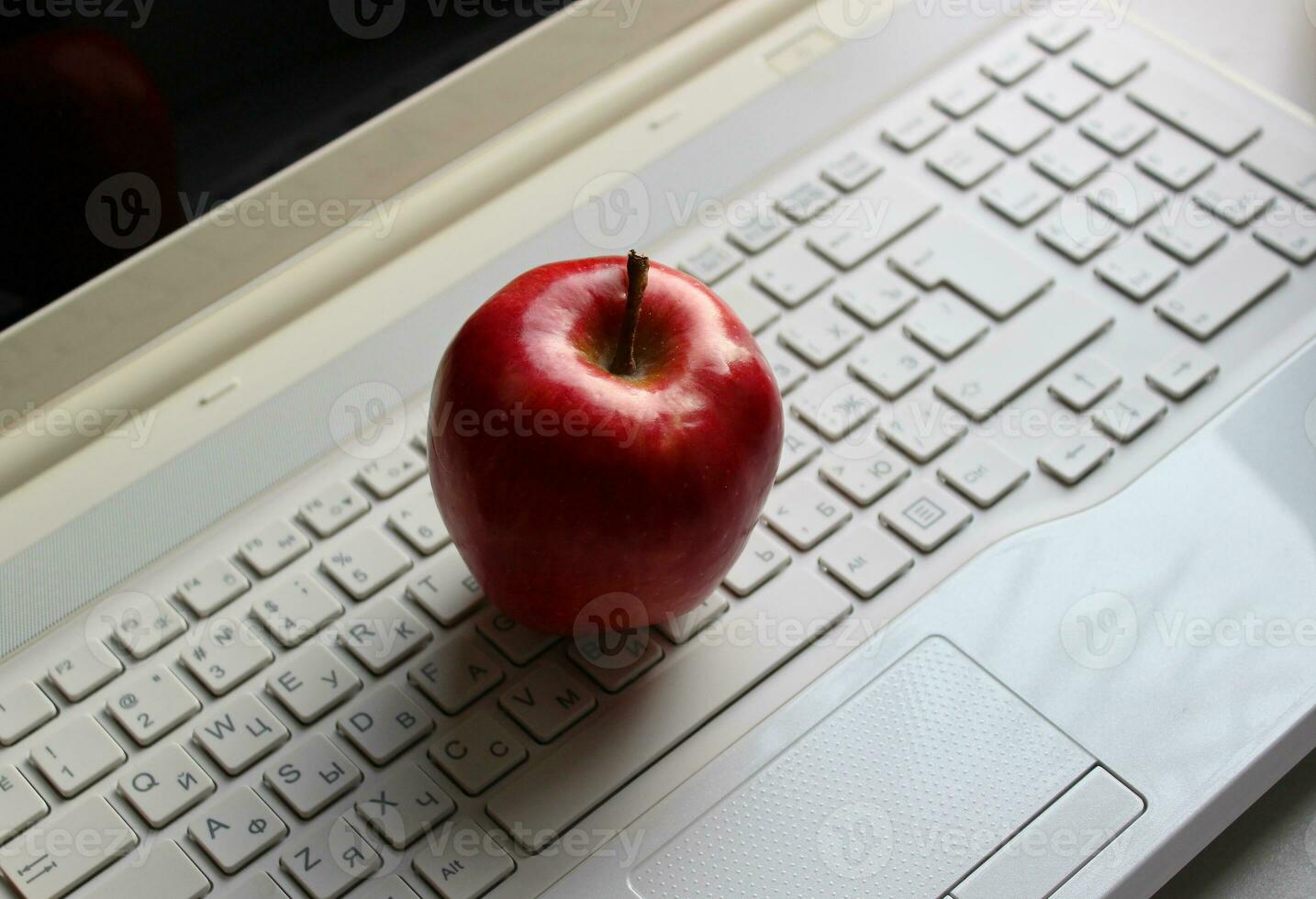 Fresco rojo manzana en ordenador portátil teclado con latín y cirílico caracteres foto