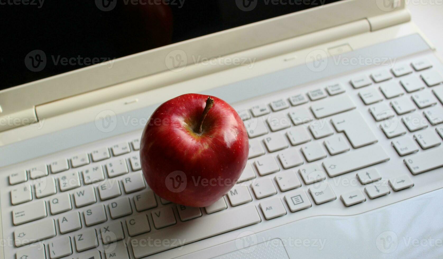 Red apple on a white computer keyboard with latin characters only stock photo