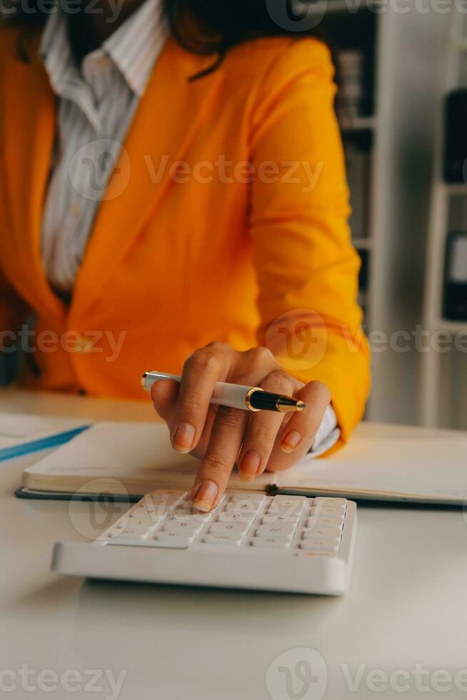 Close up woman work on project sit at desk use laptop and calculator, look at pc screen with diagrams, calculates bills, check financial documents, leads accounting of company, plan investment concept photo