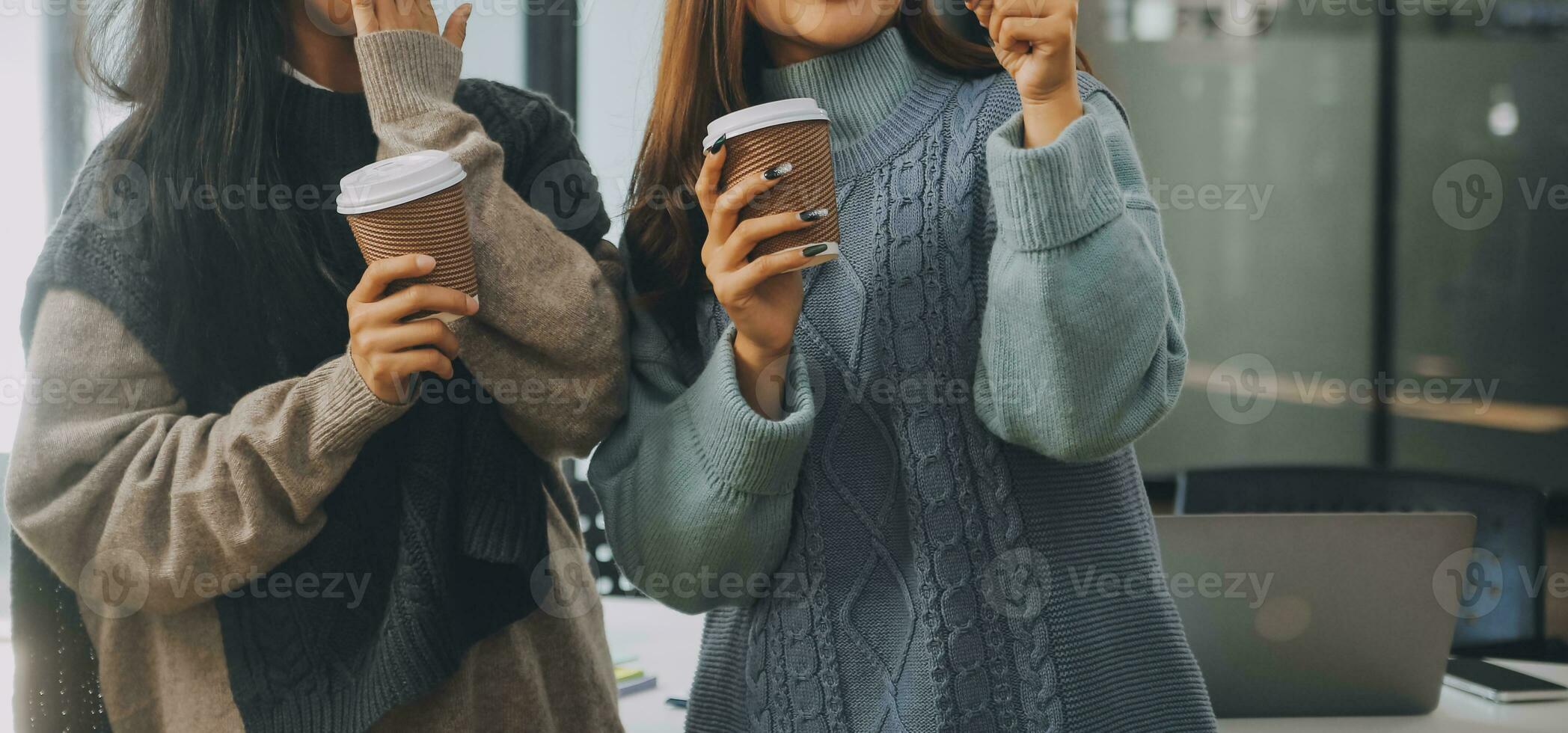 Happy colleagues having a coffee break in an office. Group of business people having a conversation in a workplace. Business professionals working in a startup. photo
