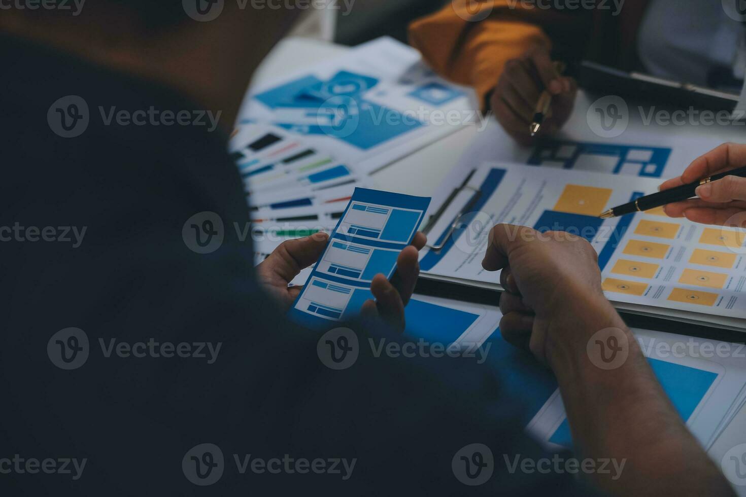 Close up ux developer and ui designer use augmented reality brainstorming about mobile app interface wireframe design on desk at modern office.Creative digital development agency photo
