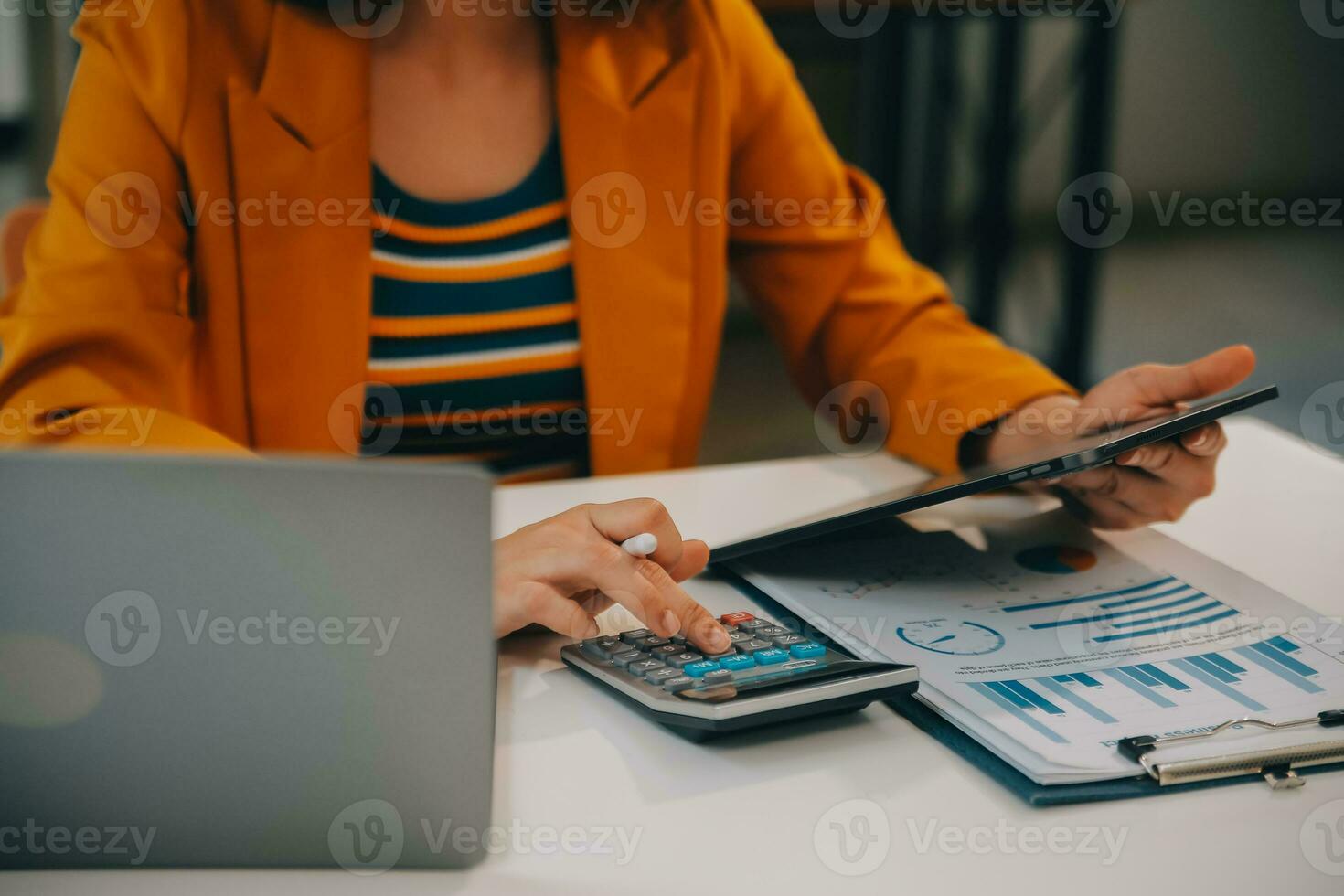 Charming Young asian businesswoman sitting on laptop computer in the office, making report calculating balance Internal Revenue Service checking document. photo
