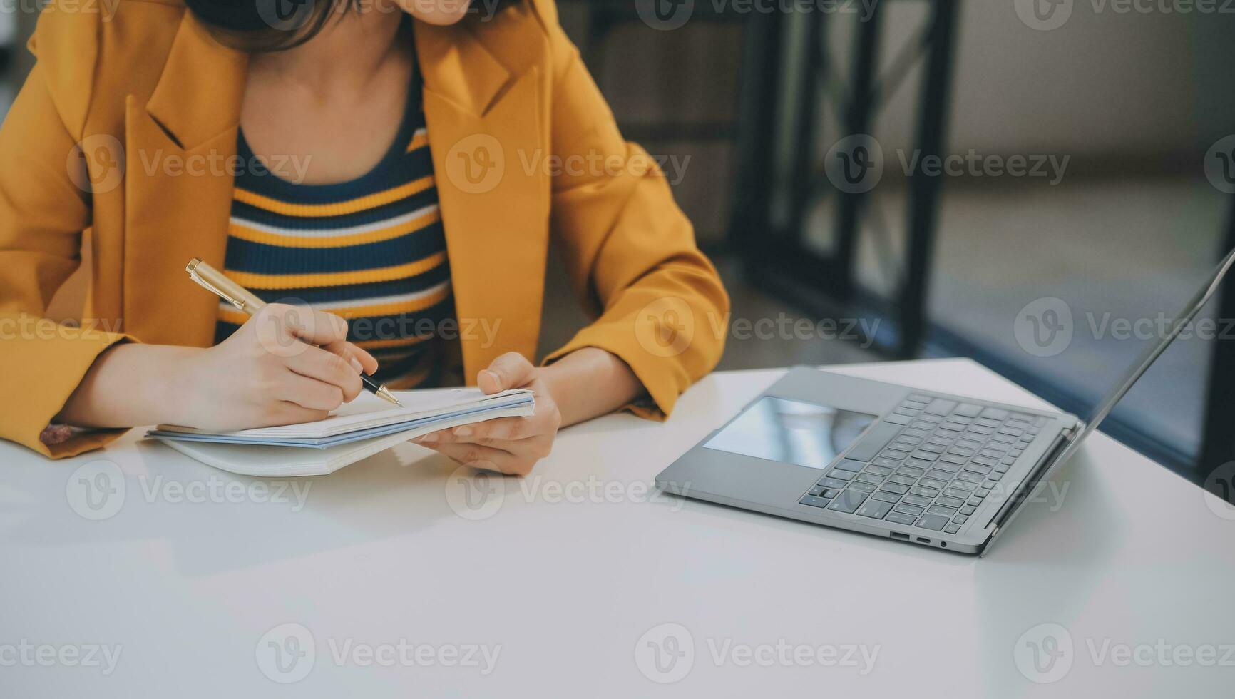 Charming Young asian businesswoman sitting on laptop computer in the office, making report calculating balance Internal Revenue Service checking document. photo