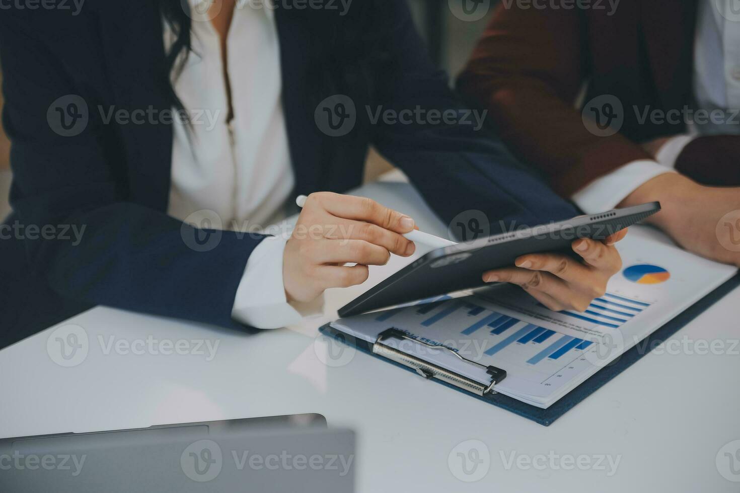 Financial analysts analyze business financial reports on a digital tablet planning investment project during a discussion at a meeting of corporate showing the results of their successful teamwork. photo