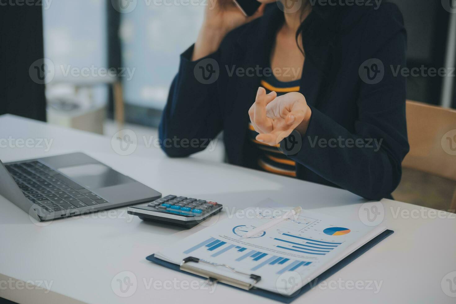 Charming Young asian businesswoman sitting on laptop computer in the office, making report calculating balance Internal Revenue Service checking document. photo