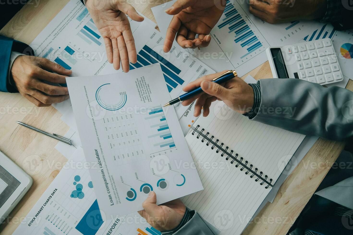 Financial analysts analyze business financial reports on a digital tablet planning investment project during a discussion at a meeting of corporate showing the results of their successful teamwork. photo