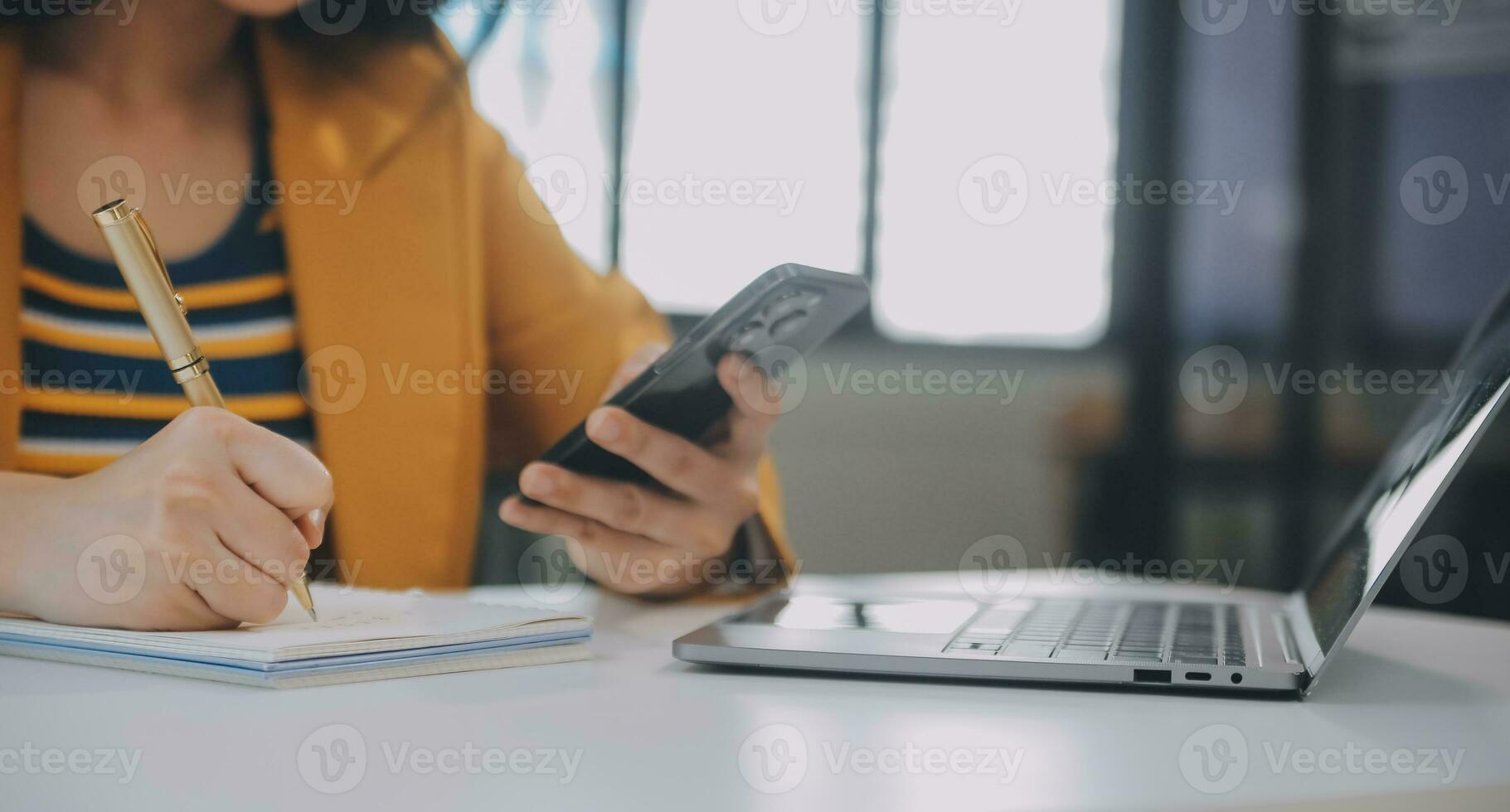 Charming Young asian businesswoman sitting on laptop computer in the office, making report calculating balance Internal Revenue Service checking document. photo