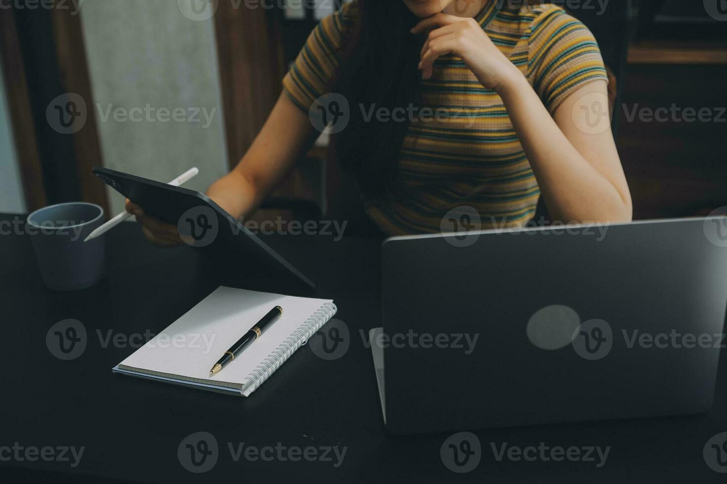 Asian Businesswoman Using laptop computer and working at office with calculator document on desk, doing planning analyzing the financial report, business plan investment, finance analysis concept. photo