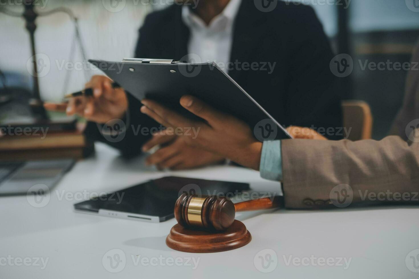 Business and lawyers discussing contract papers with brass scale on desk in office. Law, legal services, advice, justice and law concept picture with film grain effect photo