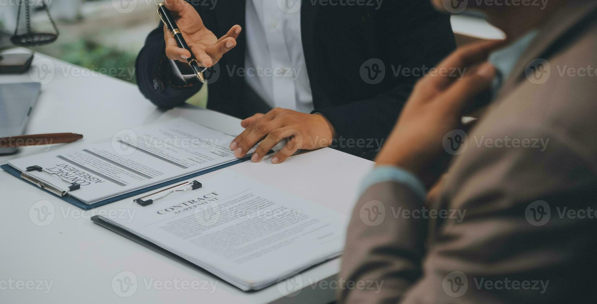 Business and lawyers discussing contract papers with brass scale on desk in office. Law, legal services, advice, justice and law concept picture with film grain effect photo