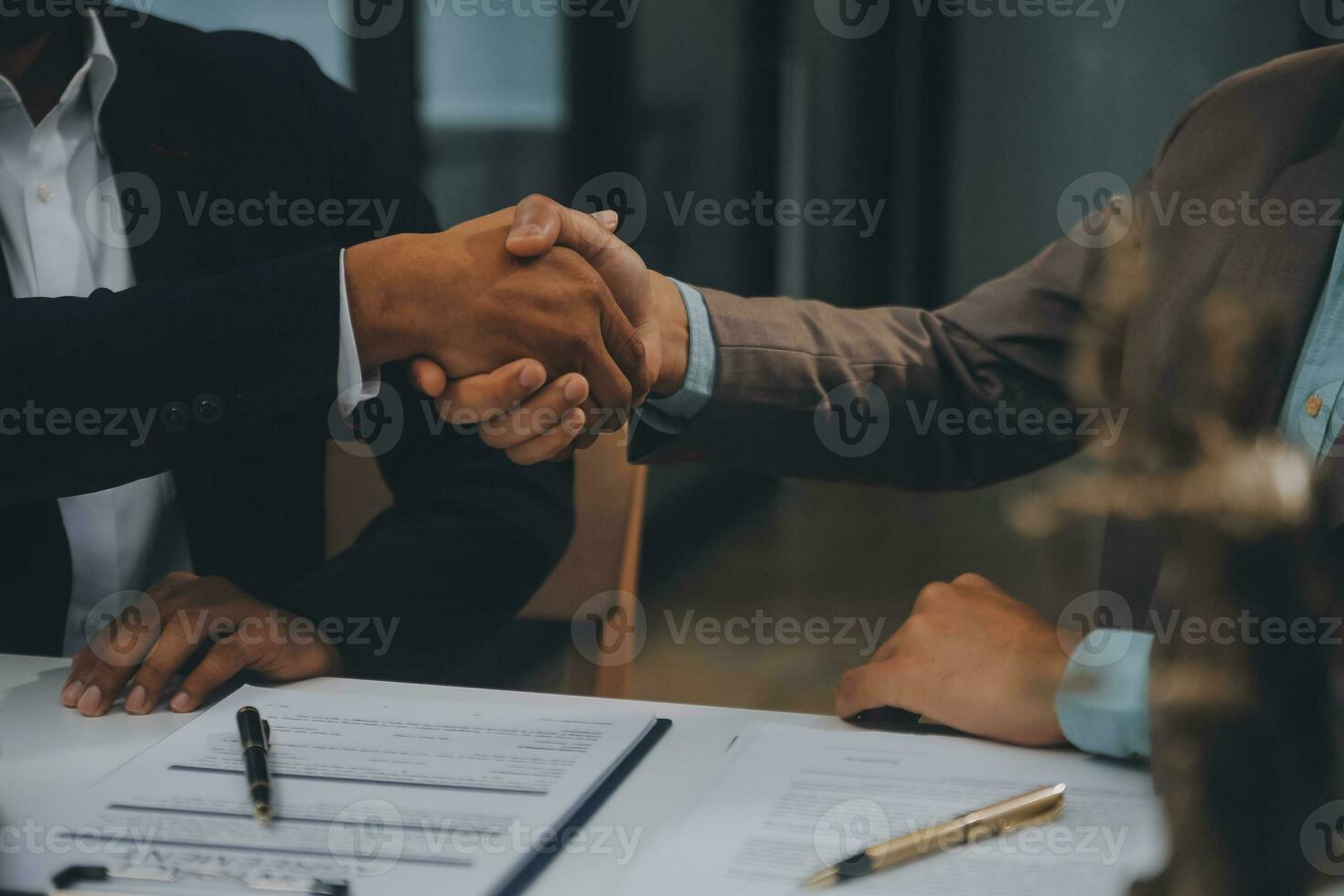 Business and lawyers discussing contract papers with brass scale on desk in office. Law, legal services, advice, justice and law concept picture with film grain effect photo