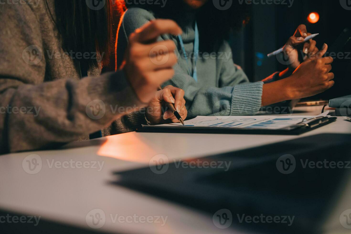 Team of software developers working on big project late at night in neon light trying to finish before deadline photo