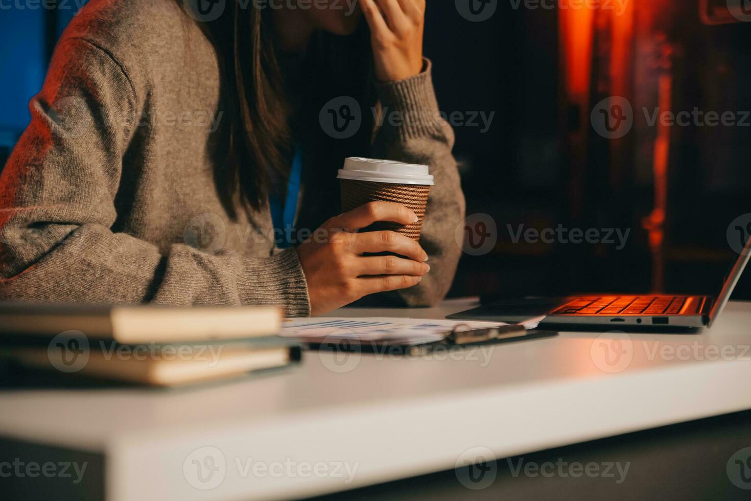 Team of software developers working on big project late at night in neon light trying to finish before deadline photo