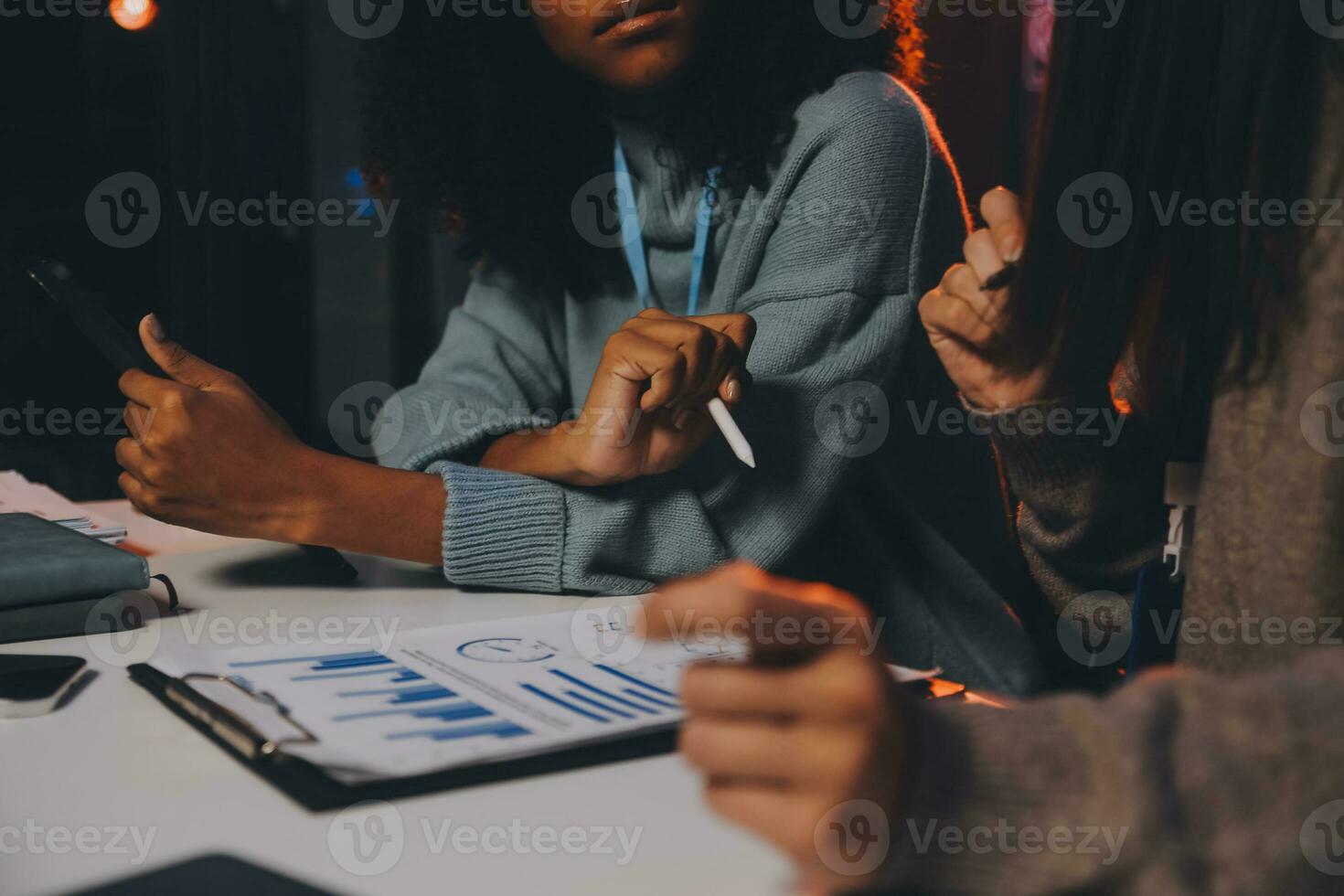Team of software developers working on big project late at night in neon light trying to finish before deadline photo
