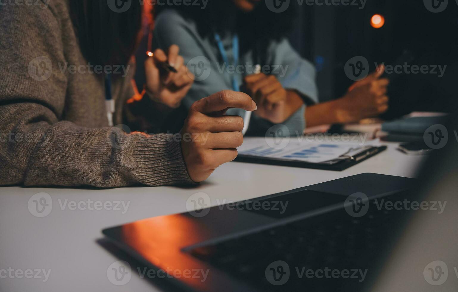 Team of software developers working on big project late at night in neon light trying to finish before deadline photo