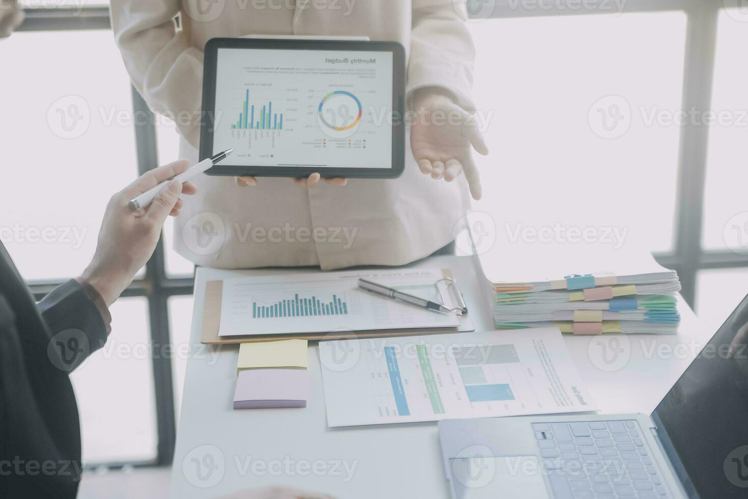 Financial analysts analyze business financial reports on a digital tablet planning investment project during a discussion at a meeting of corporate showing the results of their successful teamwork. photo