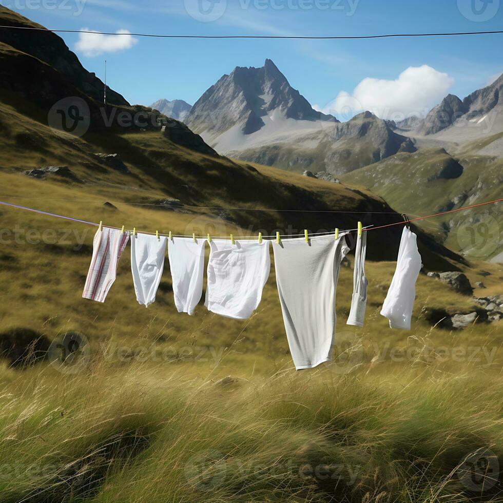 AI Generated After washing, white clean laundry dries on a rope in a field against the backdrop of the Alpine mountains photo