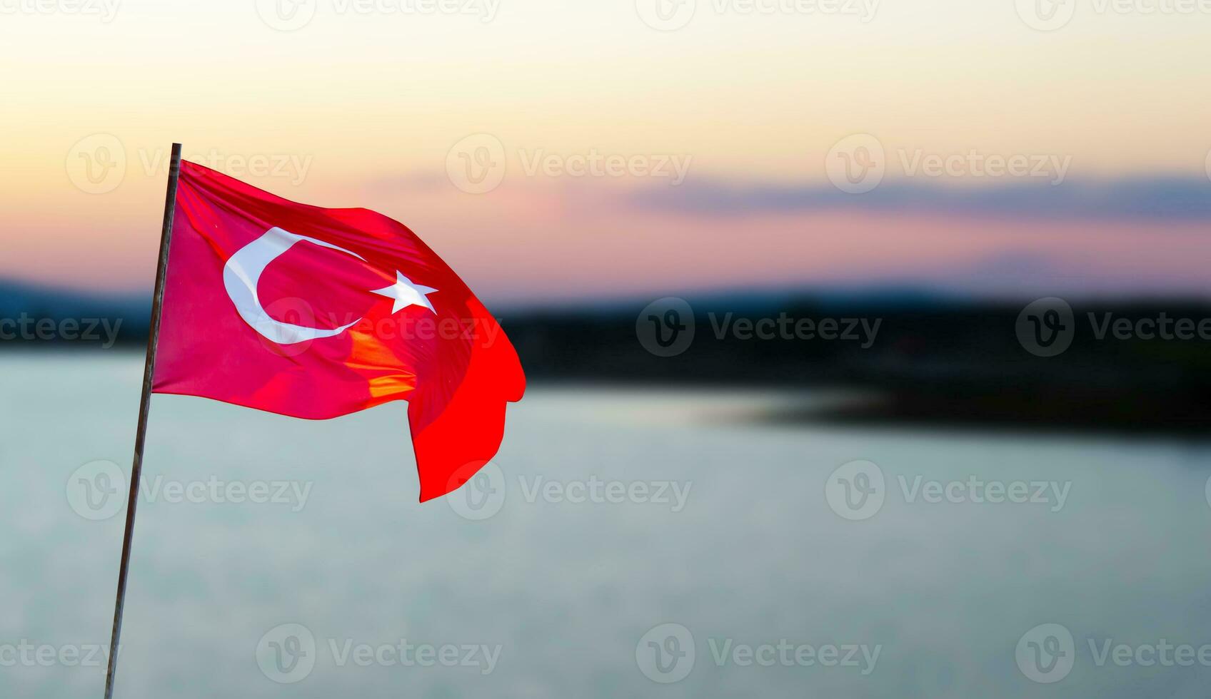 Turkish flag against lake view at the sunset. April 23, August 30, October 29 celebration photo. Copy space for text. Flag of Turkey. photo