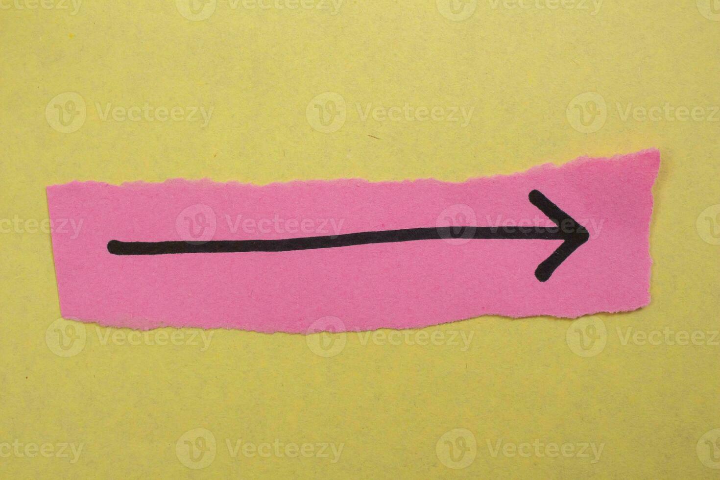 Black arrow sign on a pink paper photo