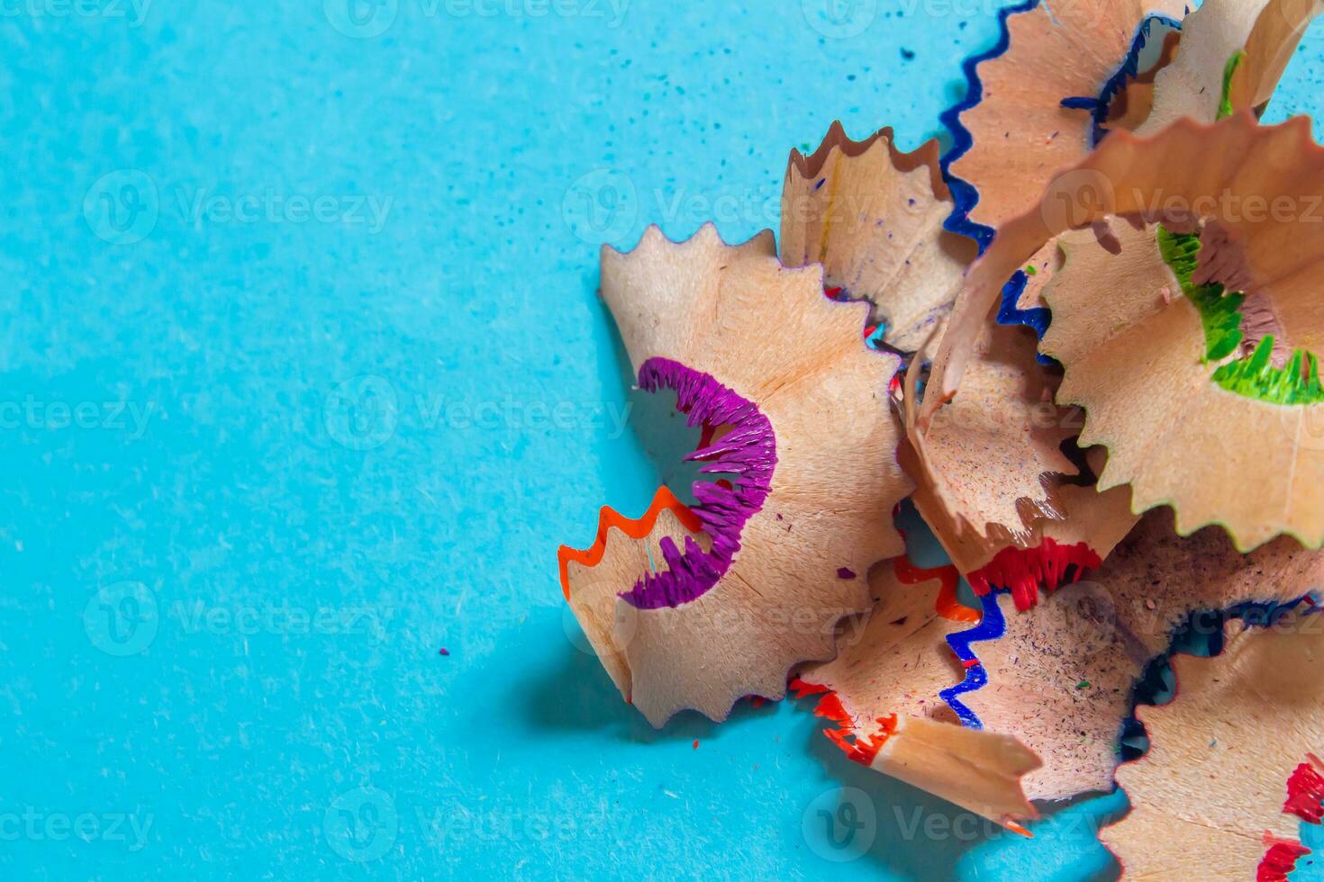 Pencil shavings isolated on a blue background. Top view, flat lay. photo