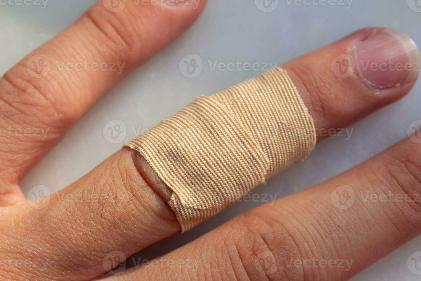 Adhesive medical plaster on hand, closeup photo