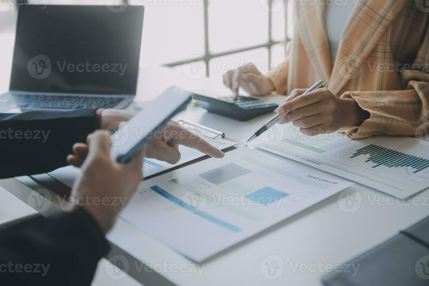 Financial analysts analyze business financial reports on a digital tablet planning investment project during a discussion at a meeting of corporate showing the results of their successful teamwork. photo