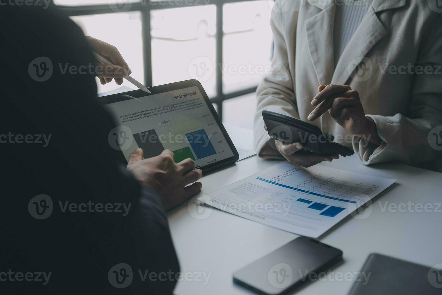 Financial analysts analyze business financial reports on a digital tablet planning investment project during a discussion at a meeting of corporate showing the results of their successful teamwork. photo