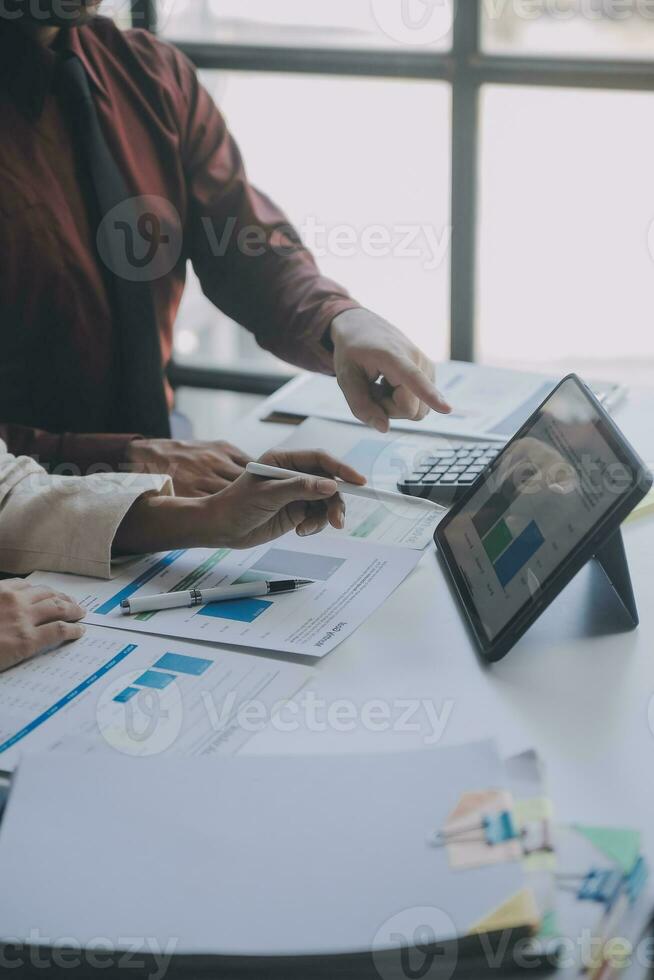 Financial analysts analyze business financial reports on a digital tablet planning investment project during a discussion at a meeting of corporate showing the results of their successful teamwork. photo