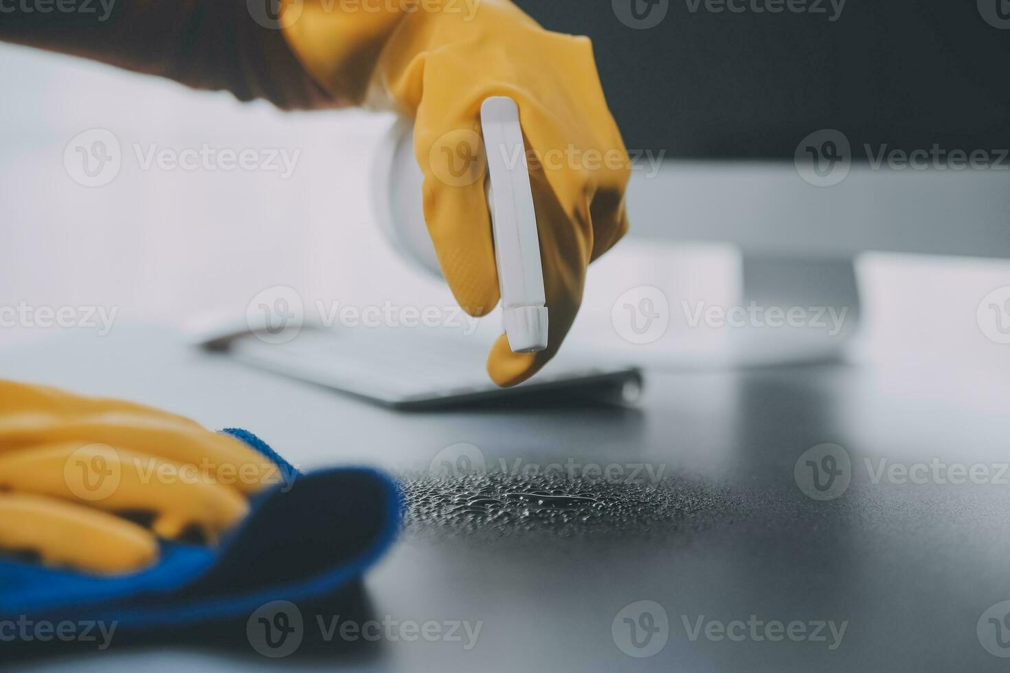 Office Cleaning Service. Janitor Spraying Desk. Workplace Hygiene photo