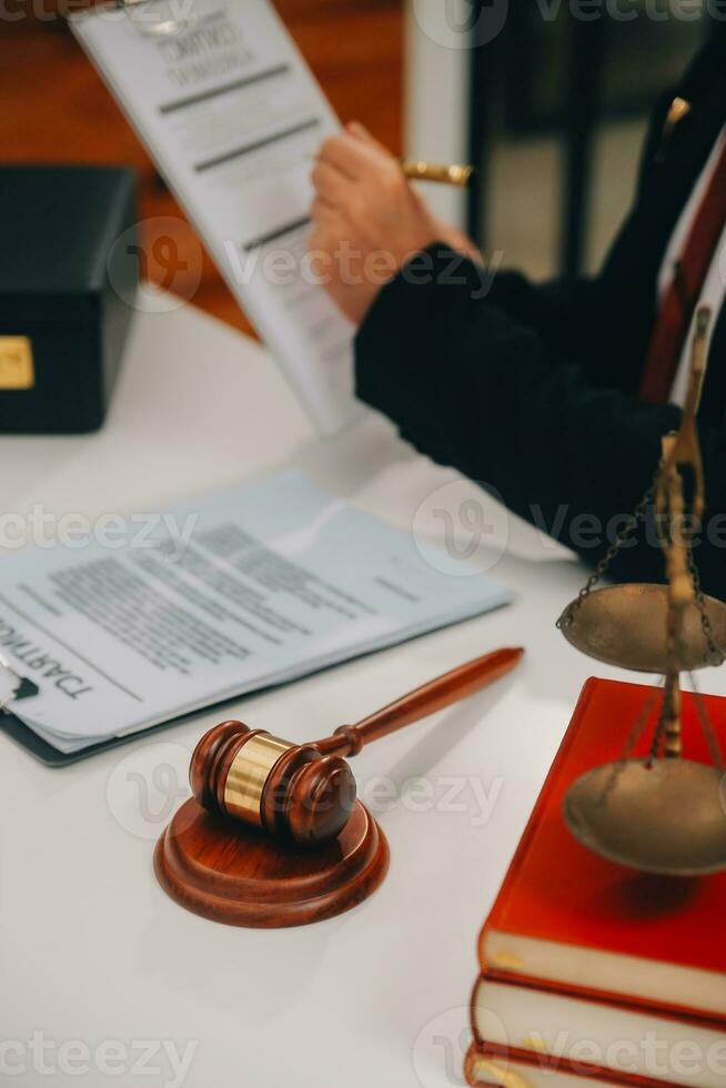 Business and lawyers discussing contract papers with brass scale on desk in office. Law, legal services, advice, justice and law concept picture with film grain effect photo