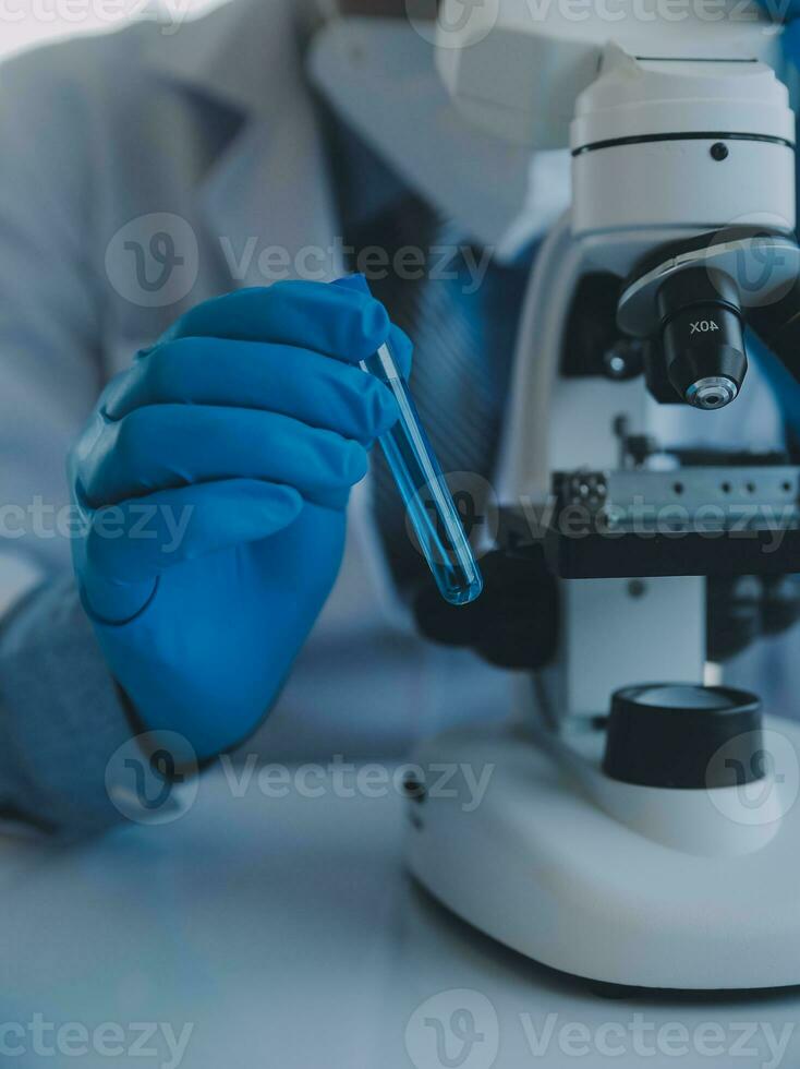 biochemical research scientist team working with microscope for coronavirus vaccine development in pharmaceutical research labolatory, selective focus photo