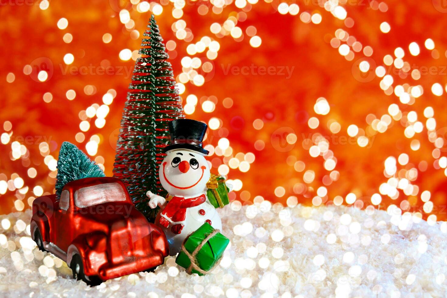 On a red background with bokeh, a cheerful snowman near a pickup truck with a Christmas tree. Christmas banner, card with place for text photo