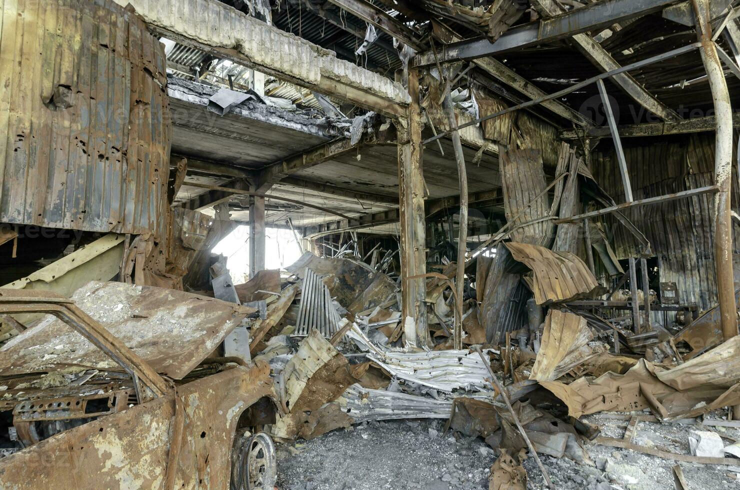 burnt car on the street of the ruined city photo