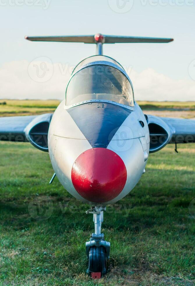 vintage sports plane on grass at the airport closeup on blue sky background photo