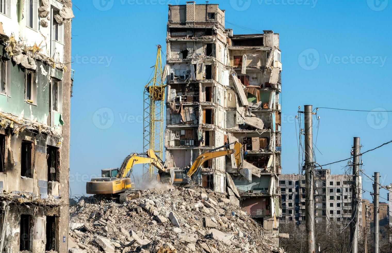 construction equipment destroys houses damaged during the war in Ukraine photo