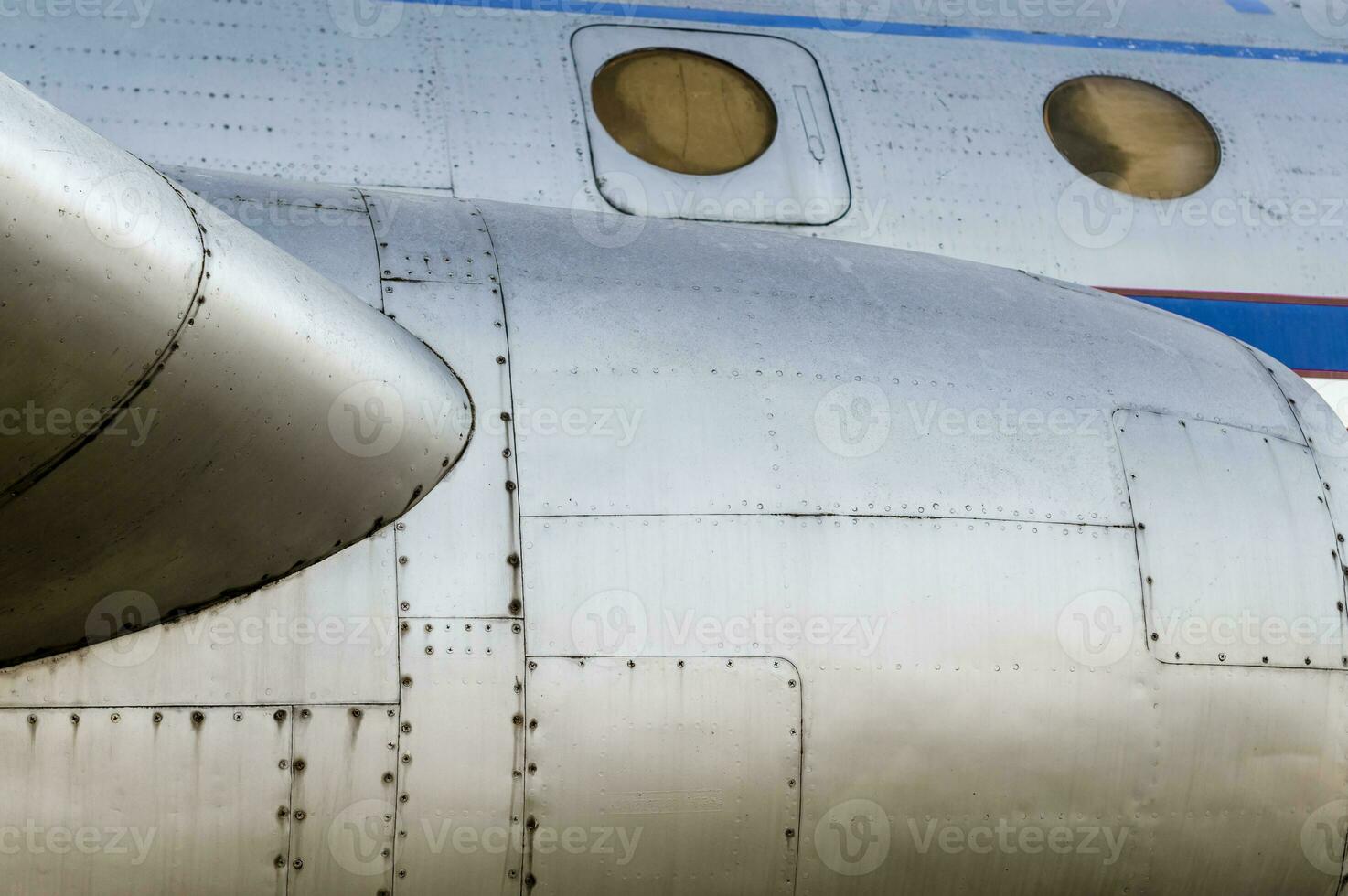 part of the plane with portholes and a turbine photo