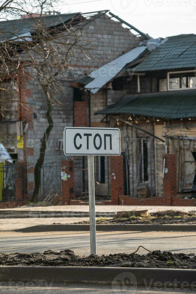 la carretera firmar con el ruso palabra detener en el arruinado ciudad en Ucrania foto